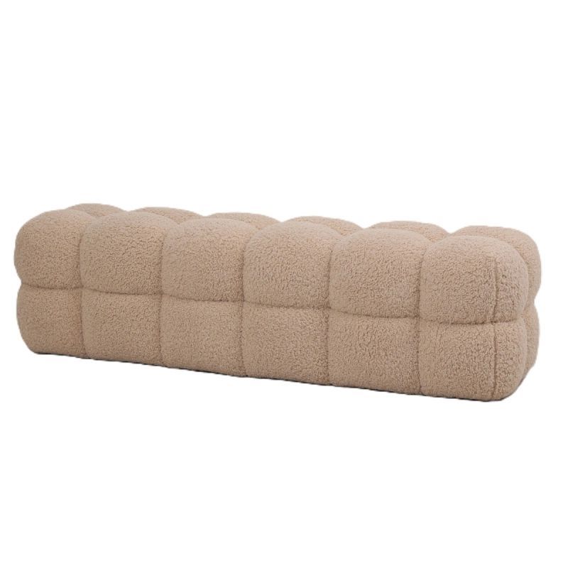 Beige, gecapitonneerde, rechthoekige bank met een gestructureerd oppervlak.