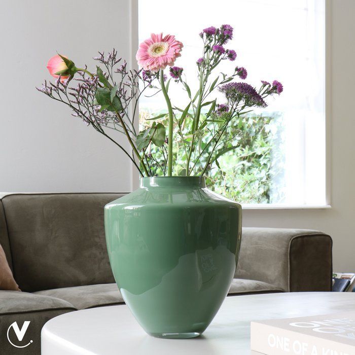Groene glazen vaas, rond lichaam, licht taps toelopende voet, korte hals.