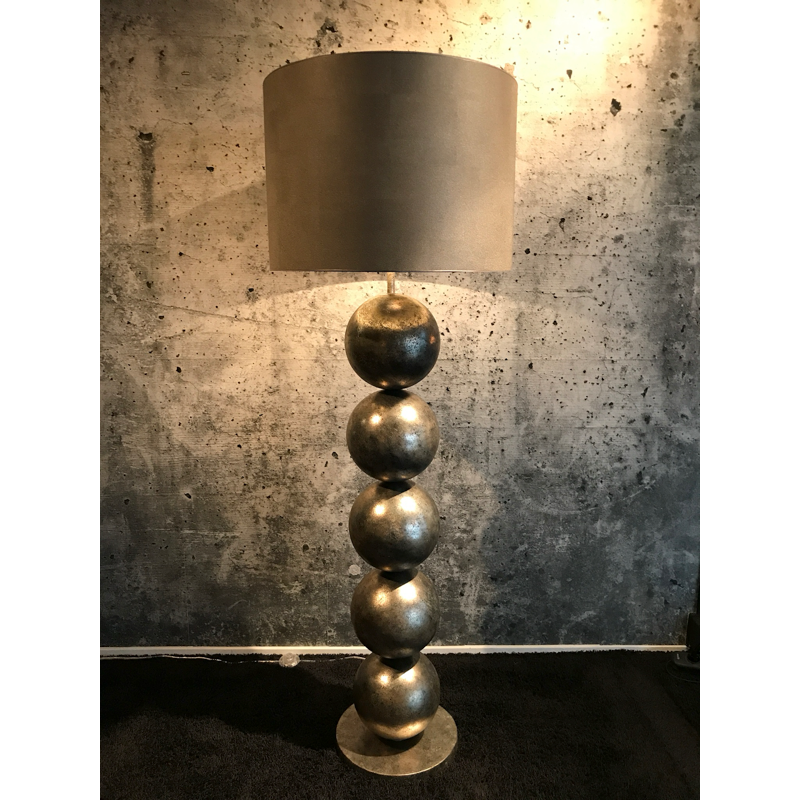 Staande lamp met gestapelde metalen bollen en een grijze cilindervormige lampenkap.