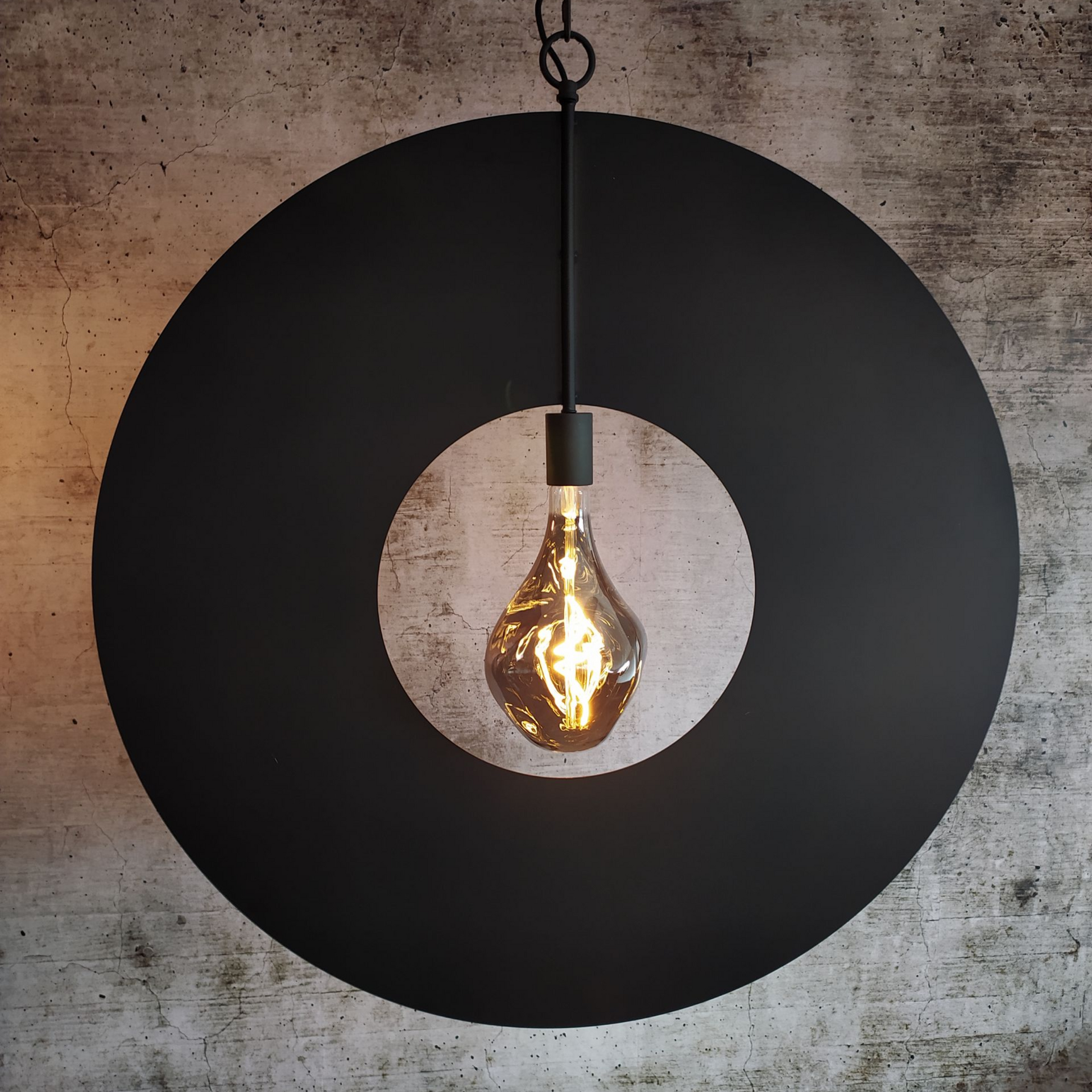 Zwarte ronde hanglamp met zichtbare gloeilamp.
