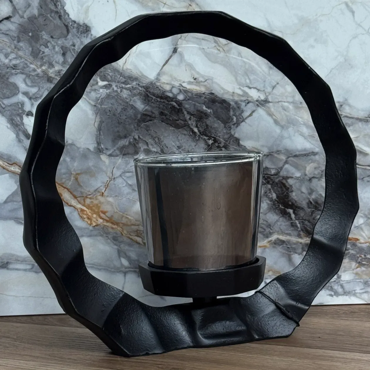 Een zwart, rond frame met een klein grijs prullenbakje in het midden onderaan.