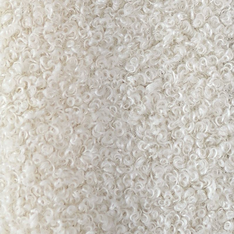 Close-up van een witte, gekrulde stof met een zacht, pluizig patroon.