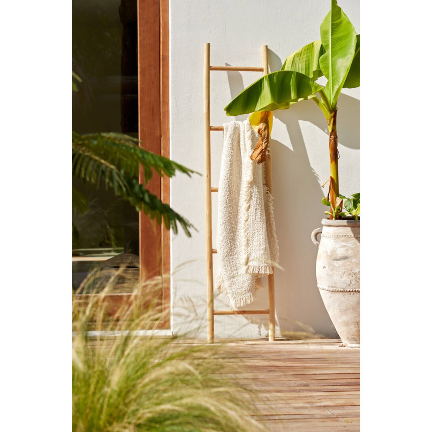 Opgevouwen beige handdoekenstapel op een witte achtergrond
