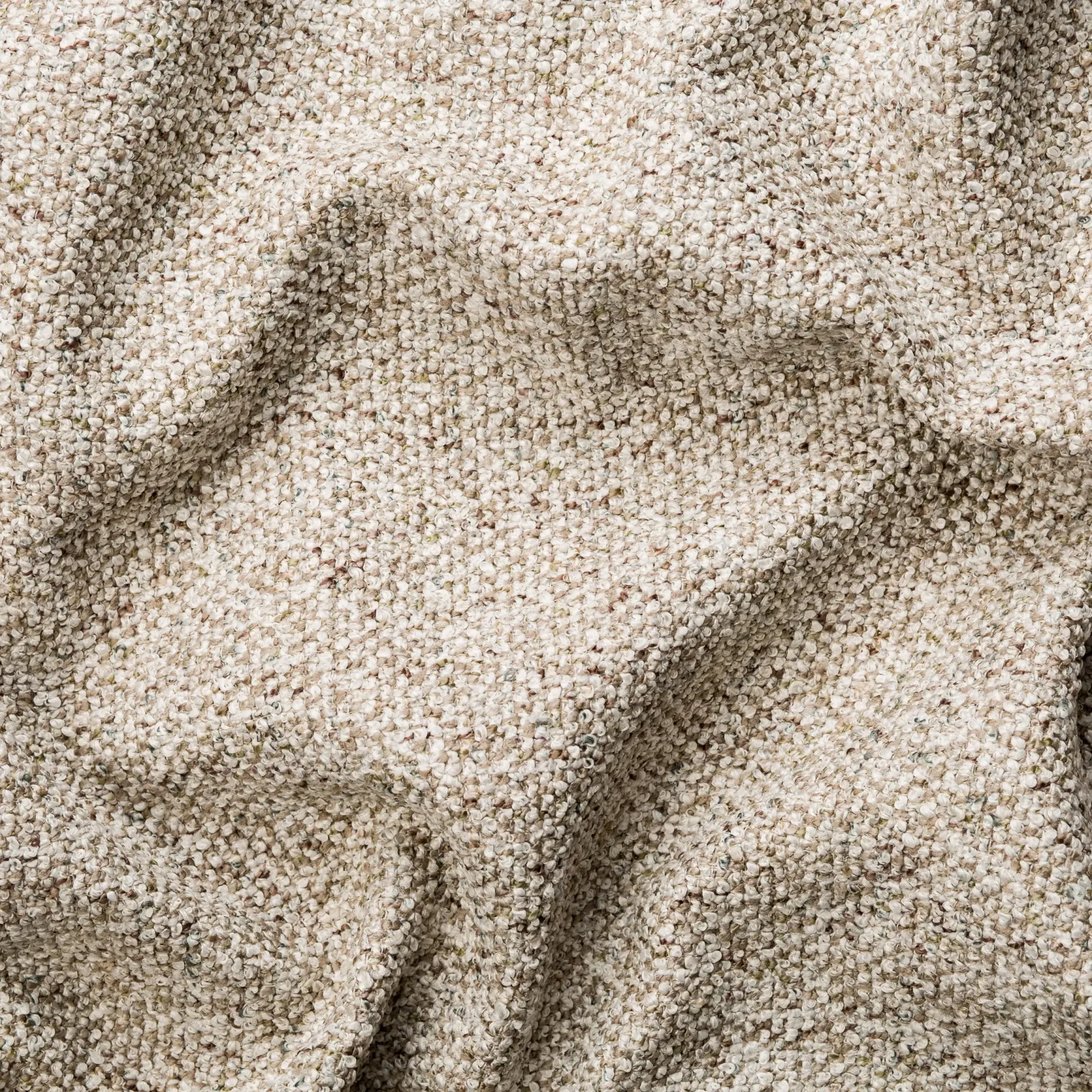 Detailopname van beige, gestructureerde stof met zachte plooien en schaduwen.