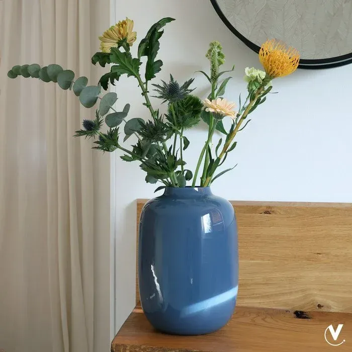 Blauwe, glanzende keramische vaas. Ovaalvormig, met een smalle opening.