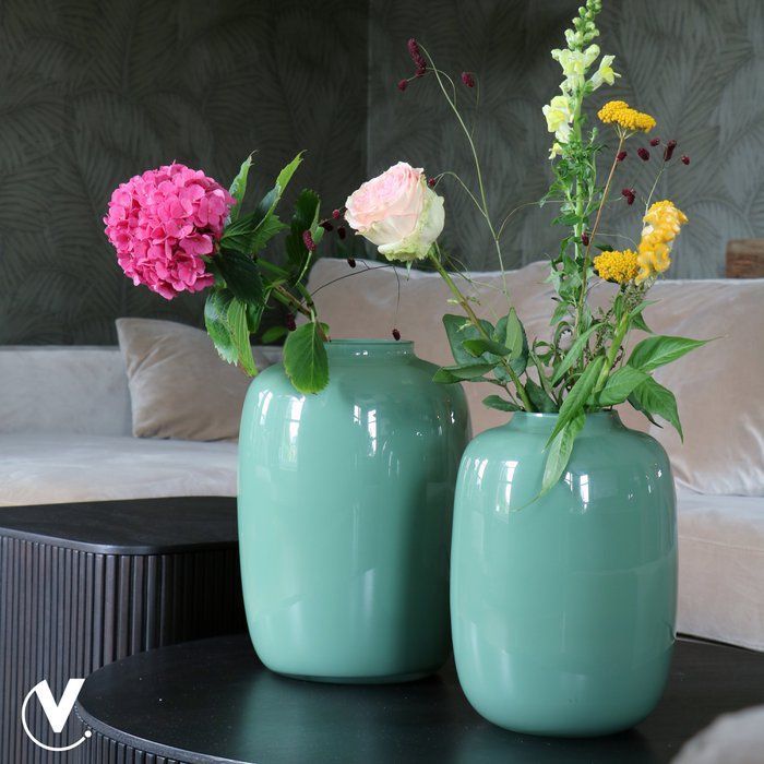 Groene, ovale vaas met een gladde, glanzende afwerking.