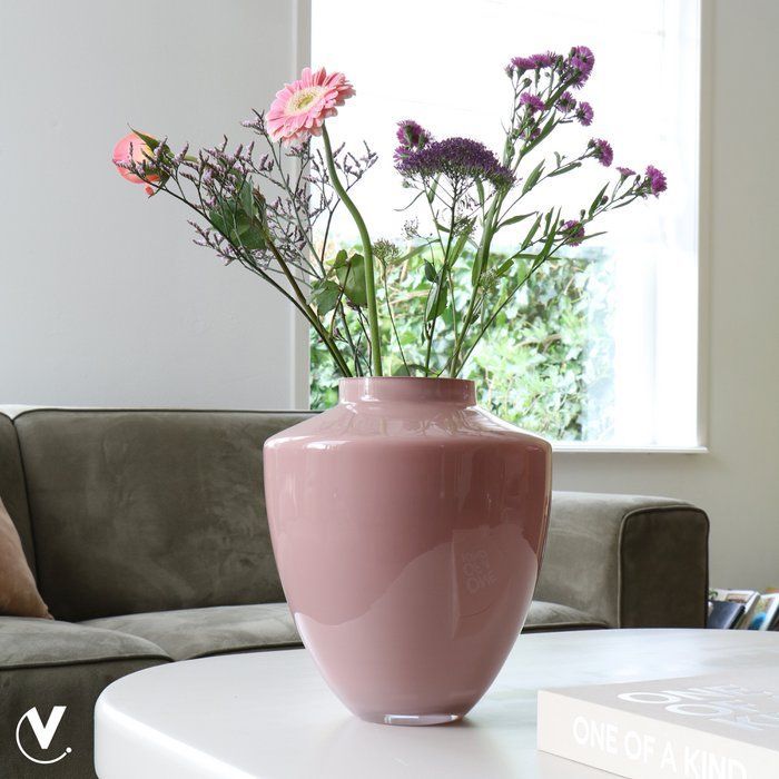 Roze, geglazuurde vaas met een ronde vorm en een smalle hals tegen een witte achtergrond.