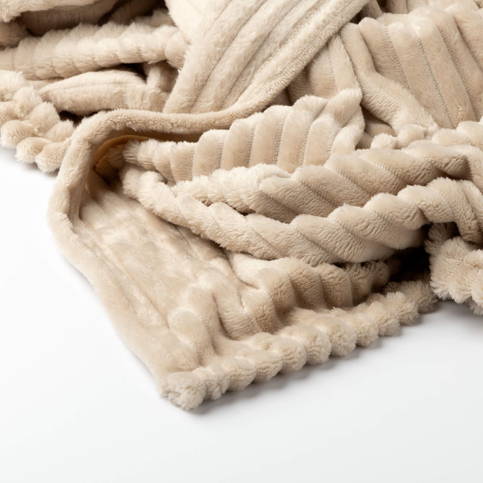 Een opgevouwen beige plaid met een dikke, verticale ribbelstructuur.