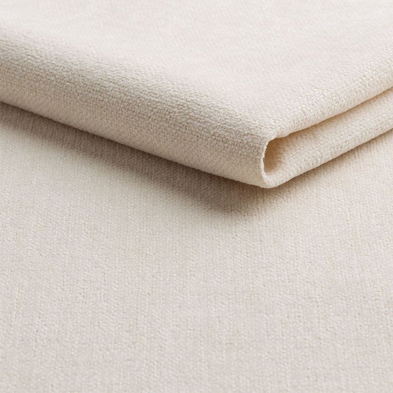 Detailopname van een opgevouwen beige stof met een geweven structuur op een lichte achtergrond.