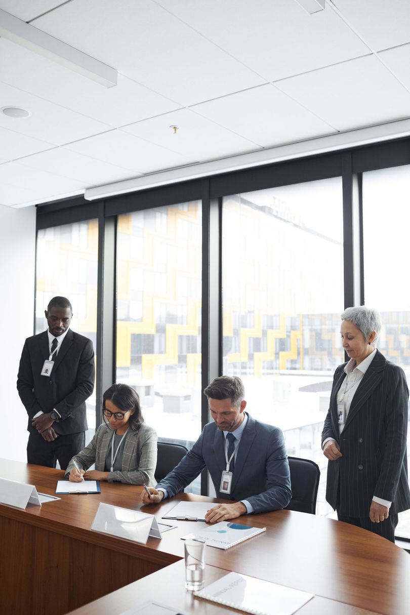 Corporate boardroom meeting with executives reviewing compliance documents