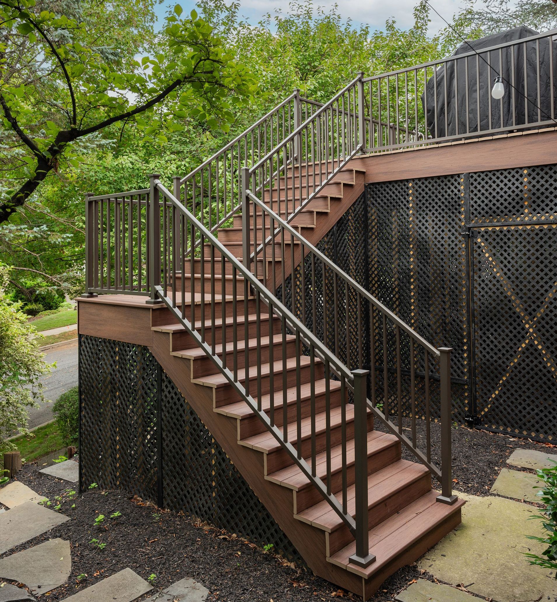 Railing A set of stairs leading up to a deck with a metal railing.
