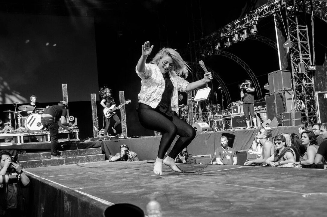 Une photo en noir et blanc d'une femme dansant sur une scène lors d'un concert.