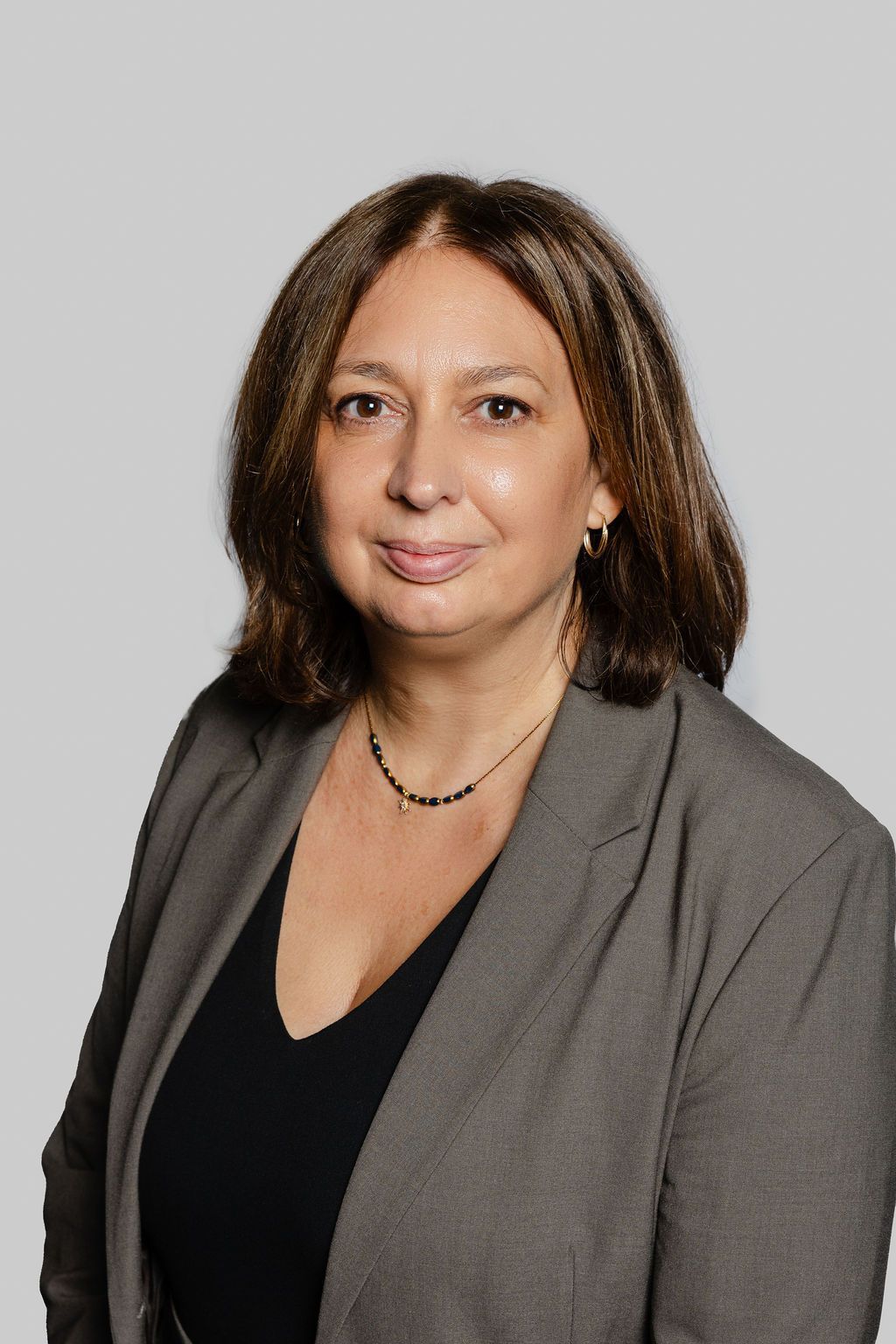 Une photo en noir et blanc d'une femme portant une veste en cuir et un collier.