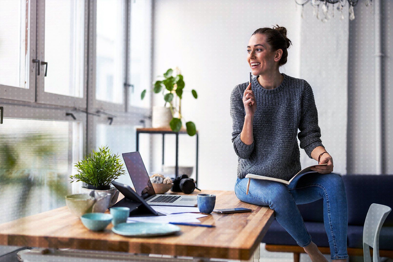 Une femme est assise à une table avec un ordinateur portable et un livre.