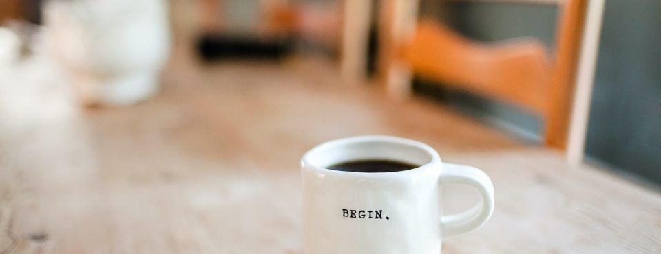 Une tasse de café est posée sur une table en bois.