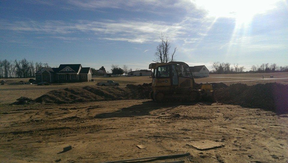 A bulldozer is digging a hole in a dirt field.