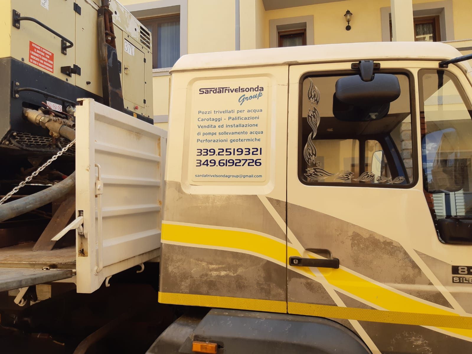 Camion bianco con vano di carico aperto; strisce gialle e grigie sui lati Sarda Trivelsonda Group Olbia Loiri Porto San Paolo - Loiri (SS)