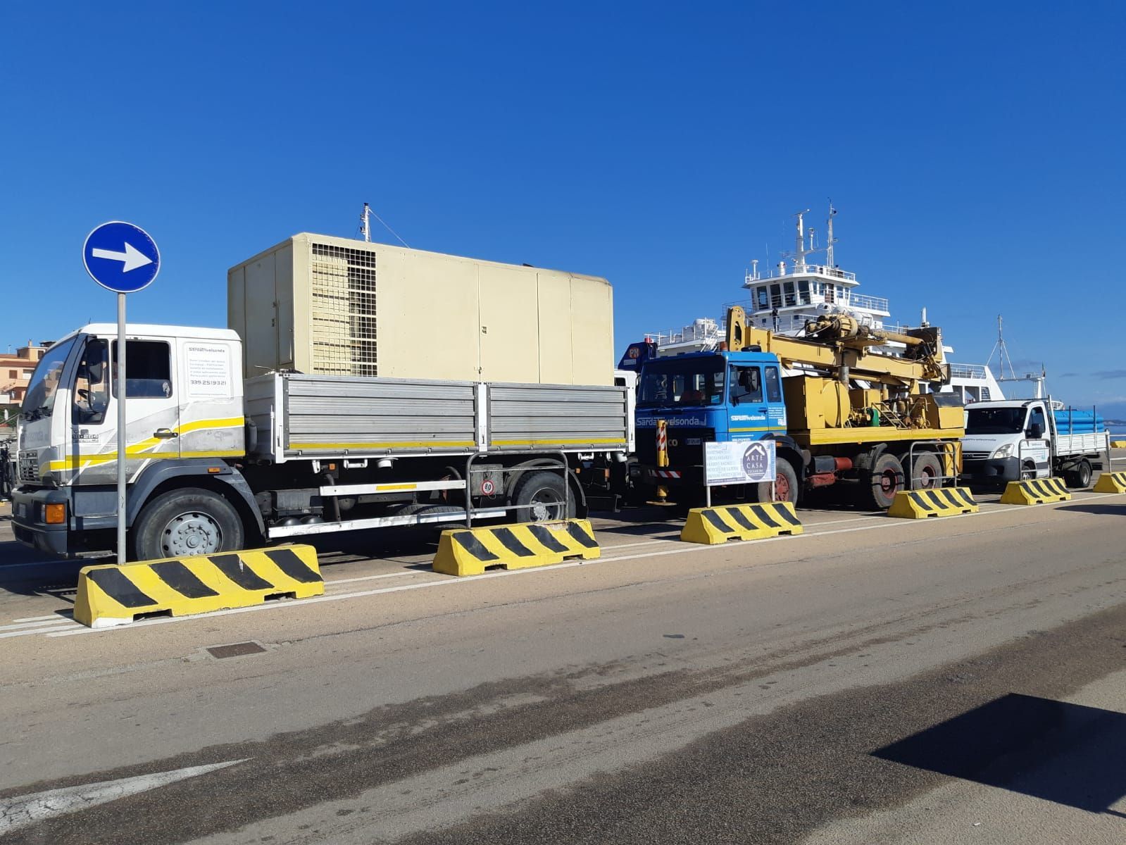 Camion parcheggiati vicino a un porto, uno dei quali con un grande container sul cassone Sarda Trivelsonda Group Olbia Loiri Porto San Paolo - Loiri (SS)