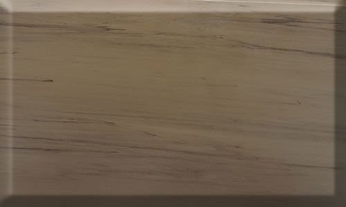 Beige countertop with dark veining and a recessed edge.