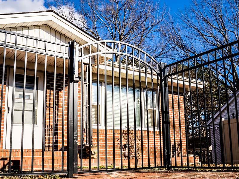 A brick house with a metal gate in front of it.