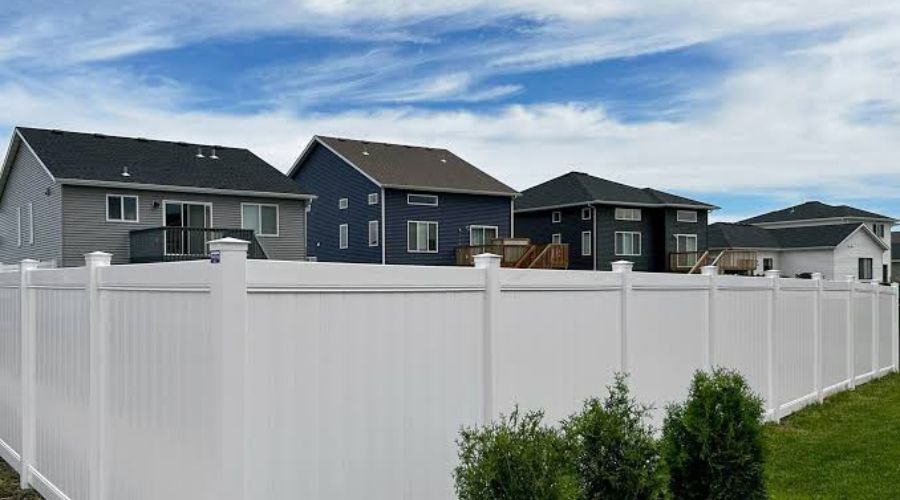 White vinyl privacy fence installation in a residential Fargo, ND backyard.