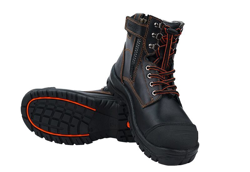 A pair of black and orange safety boots on a white background.