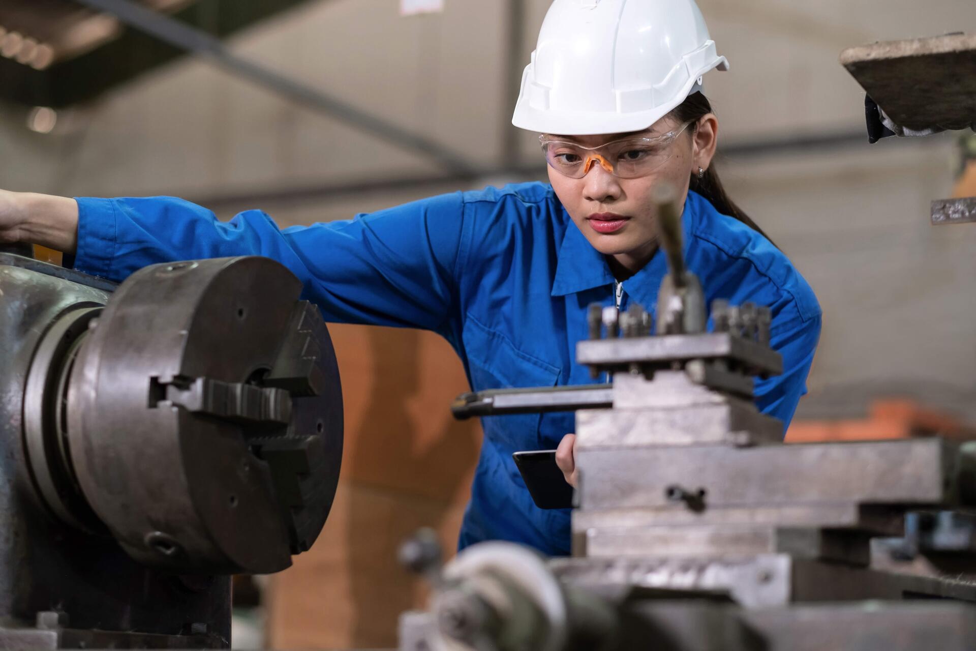 A woman is working on a machine in a factory.