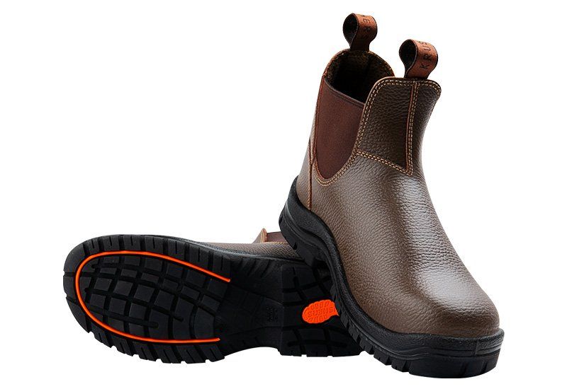 A pair of brown boots with an orange sole on a white background