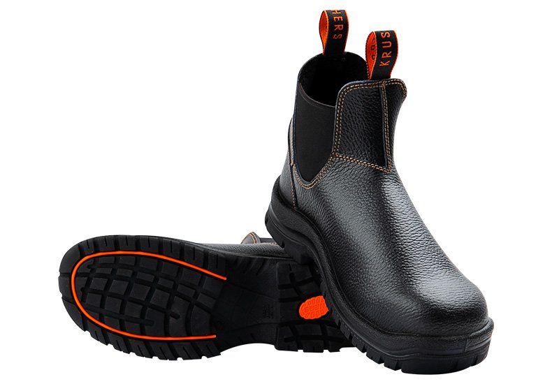 A pair of black boots with an orange sole on a white background