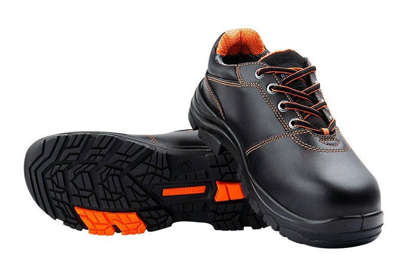 A pair of black and orange safety shoes on a white background