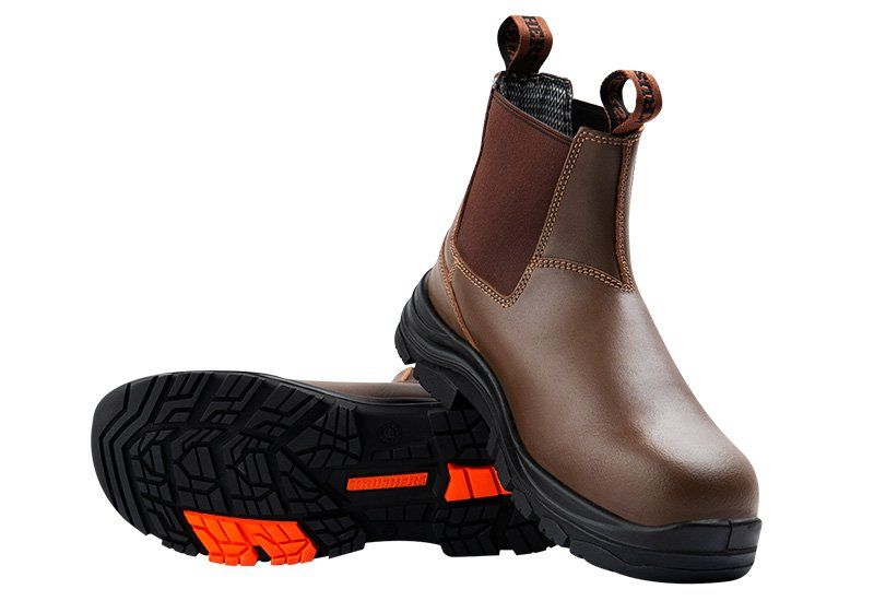 A pair of brown boots with orange soles on a white background