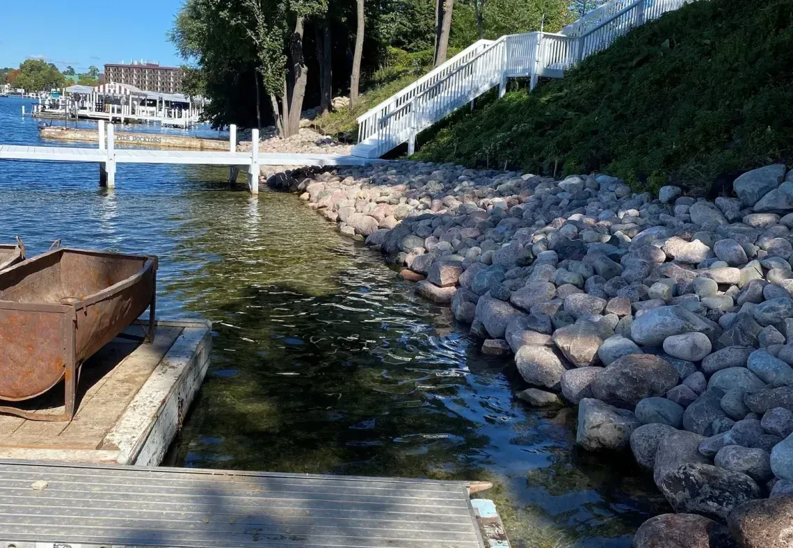 White dock with rocks on the shoreline