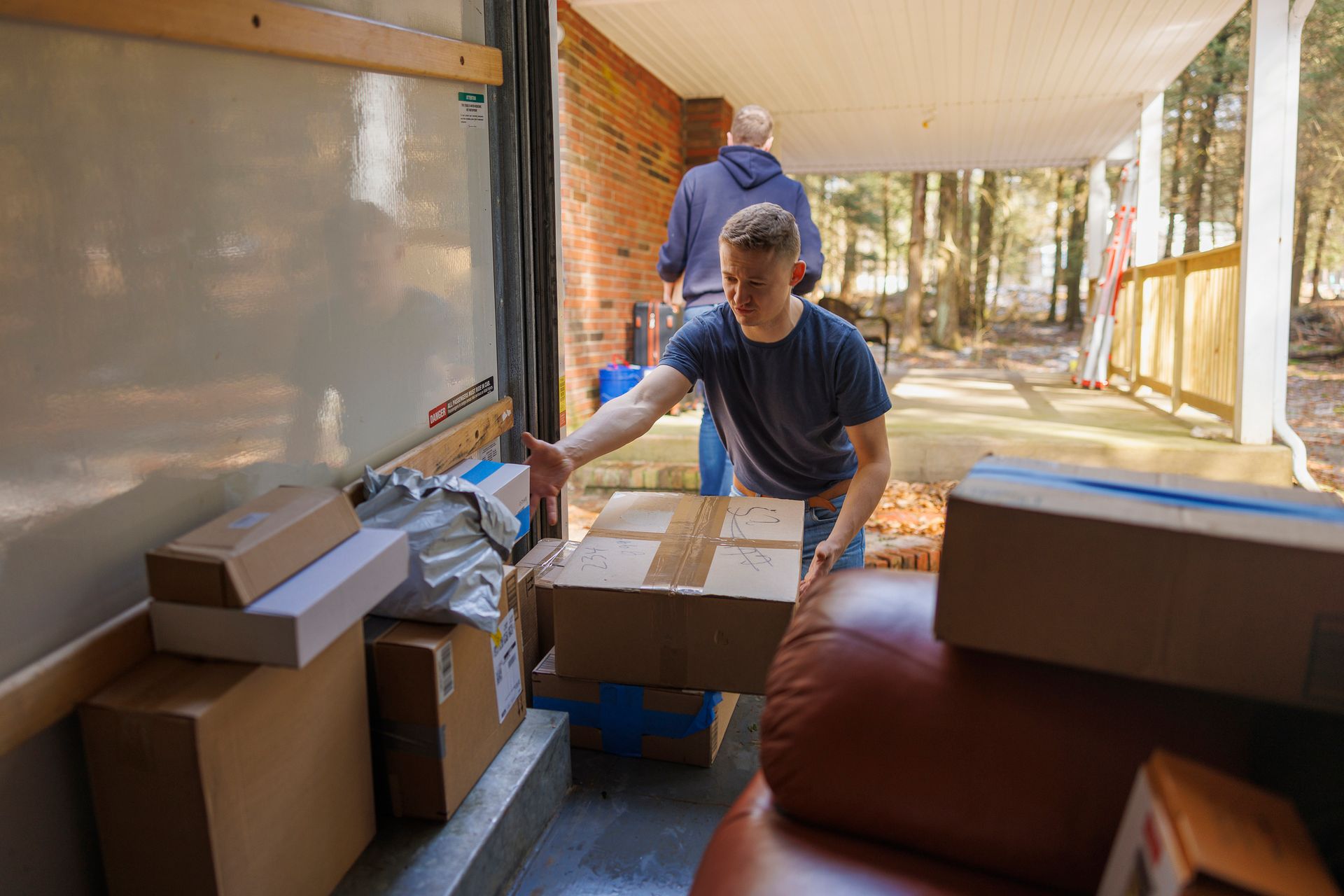 Two men unloading boxes from truck. Two men unloading boxes from truck.