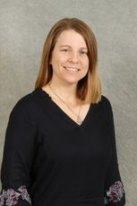 Woman with shoulder-length blonde hair wearing a black V-neck shirt smiling at the camera.