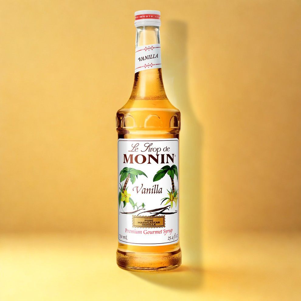 MONIN vanilla syrup bottle on a yellow background