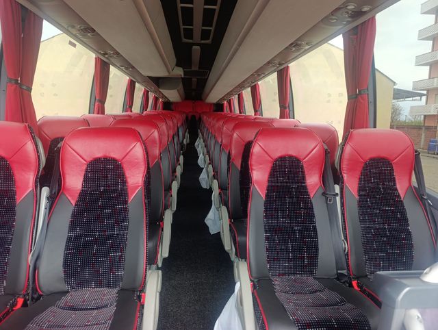 Interno vuoto di un autobus con file di sedili rossi e neri rivolti in avanti