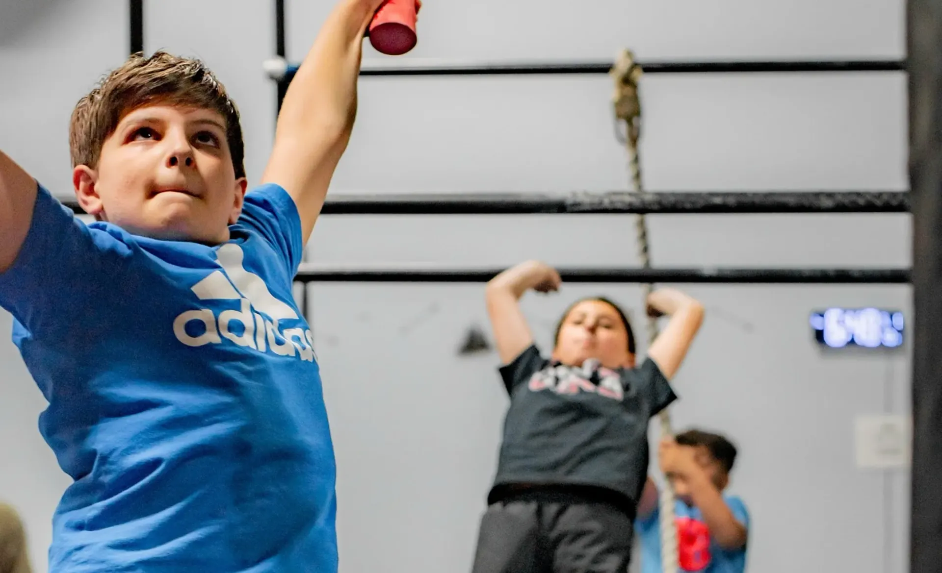 Children exercising in a gym, raising their arms during a workout class