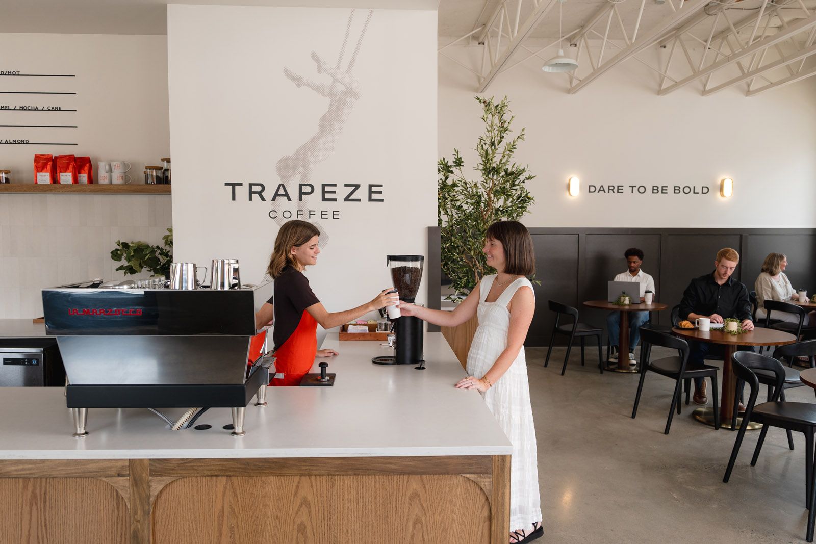A long wooden counter in Livano Nations with a coffee machine.