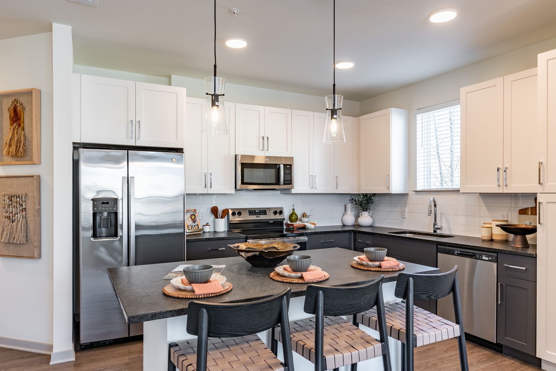 A kitchen with white cabinets , stainless steel appliances and a large island.