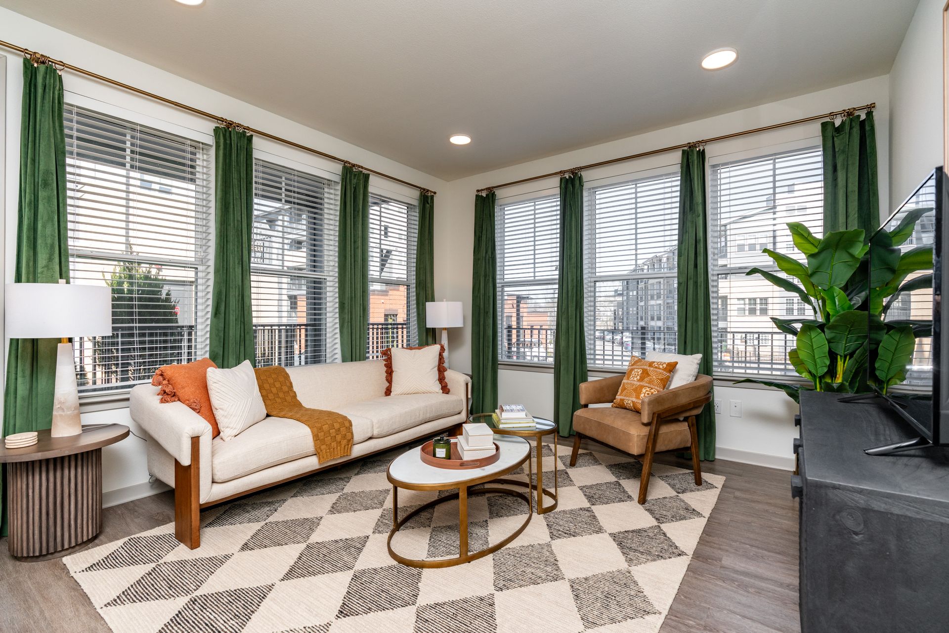 A living room with a couch , chair , coffee table and television at Livano Nations