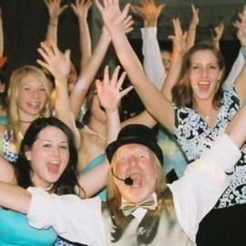 Cheering crowd with raised arms and smiling faces at a lively event