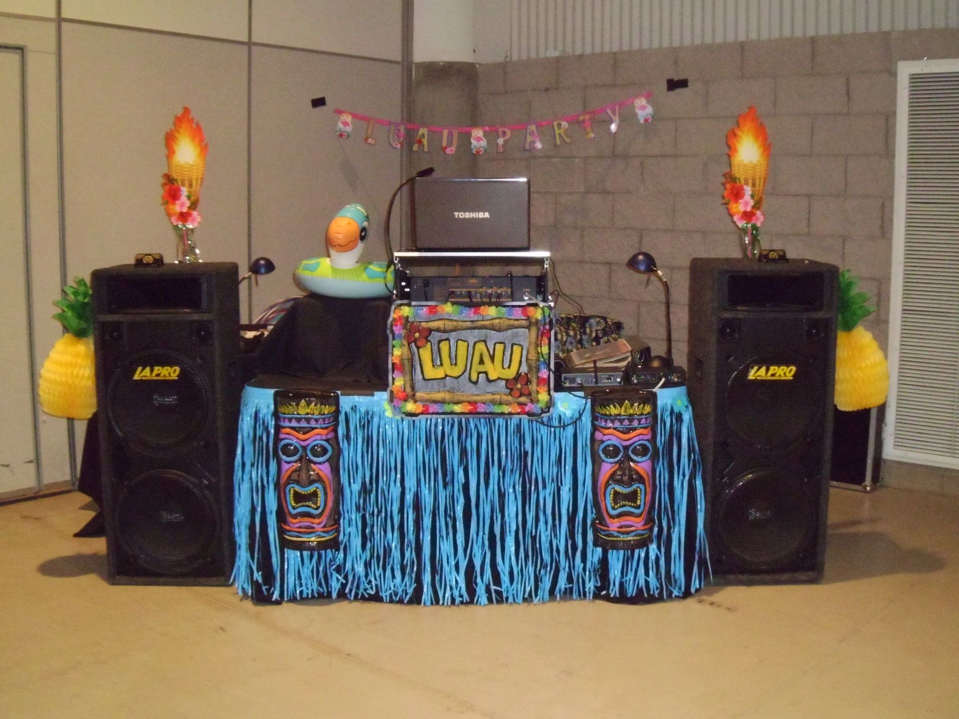 Colorful party DJ booth with speakers, balloons, and festive decorations on a table indoors