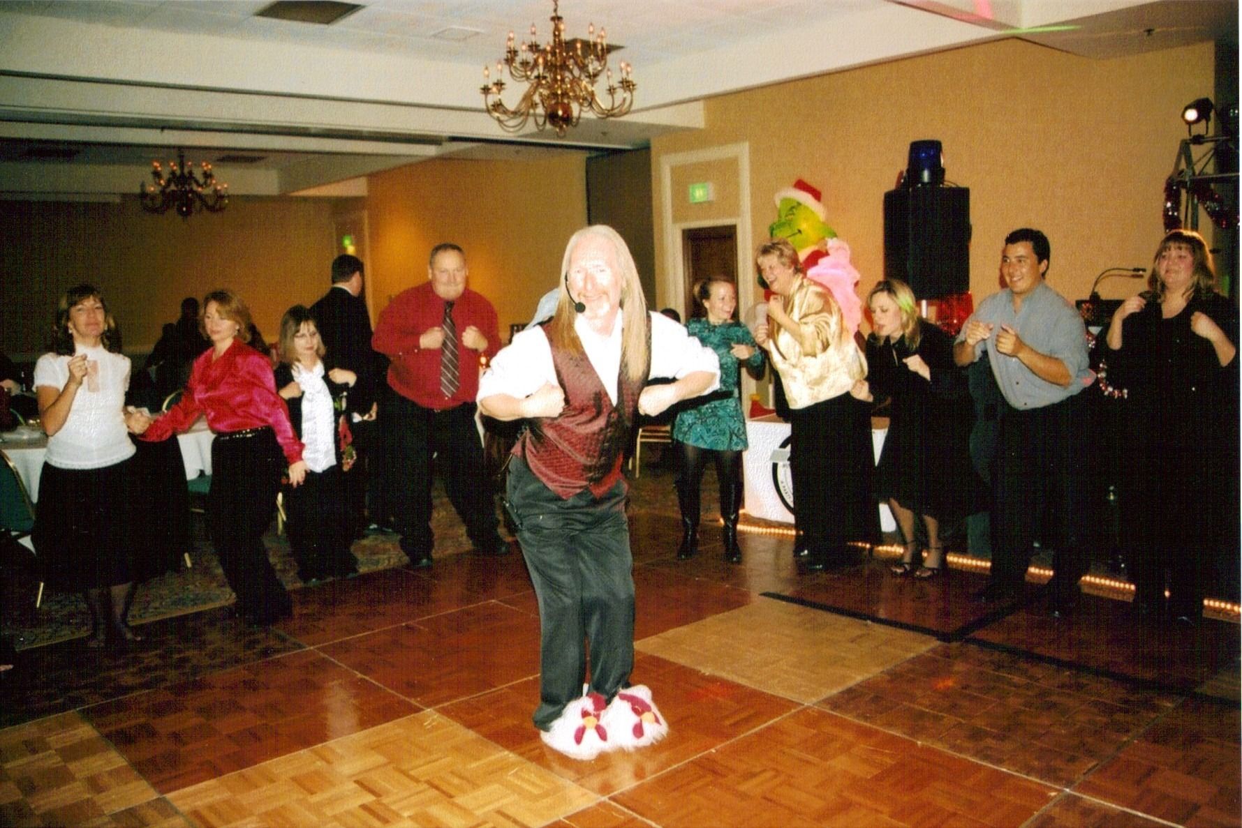 Costumed dancers performing in a banquet hall with onlookers around the room