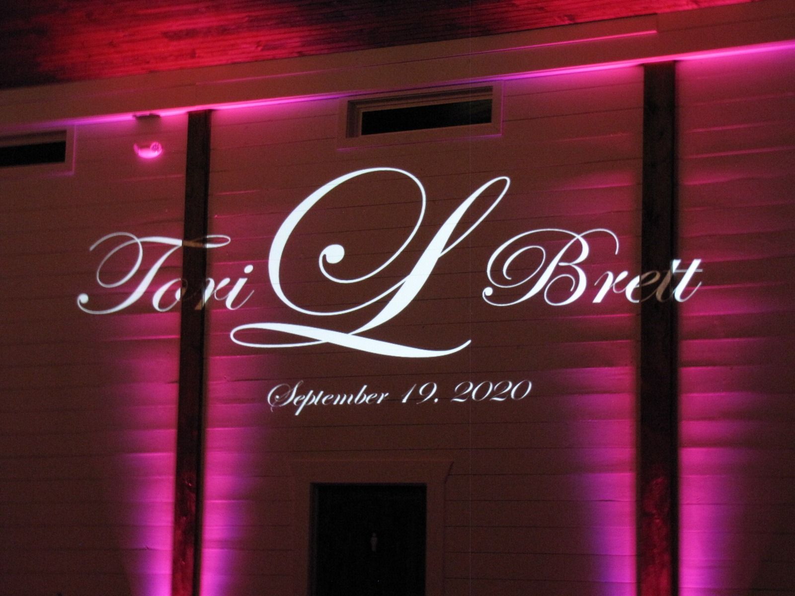 Tori L. Brett signage lit in pink on a brick wall, with “September 19, 2020” beneath.