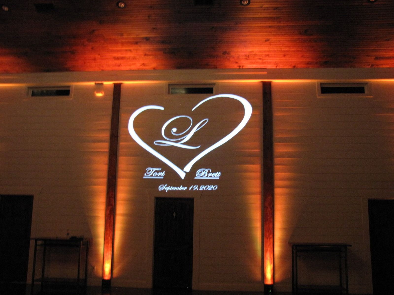 Lit wall with glowing heart logo and text on a building facade at night