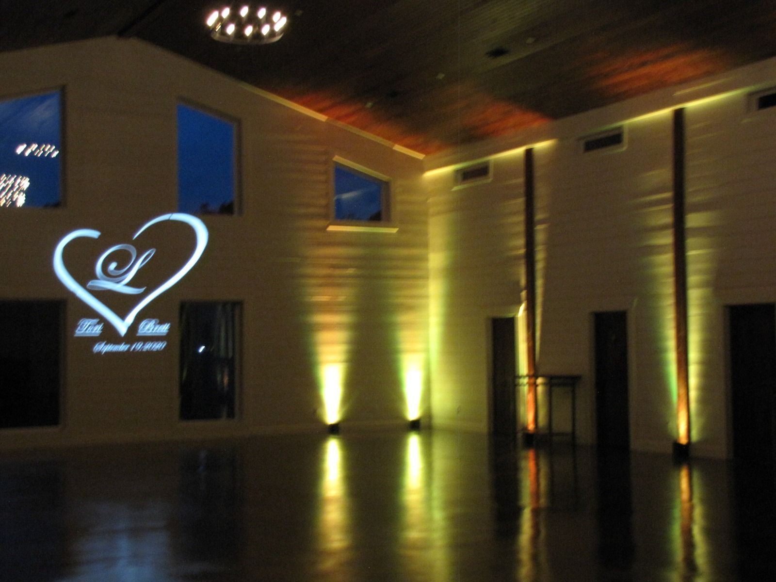 Dimly lit modern lobby with gold wall lights and a glowing heart logo on the left wall
