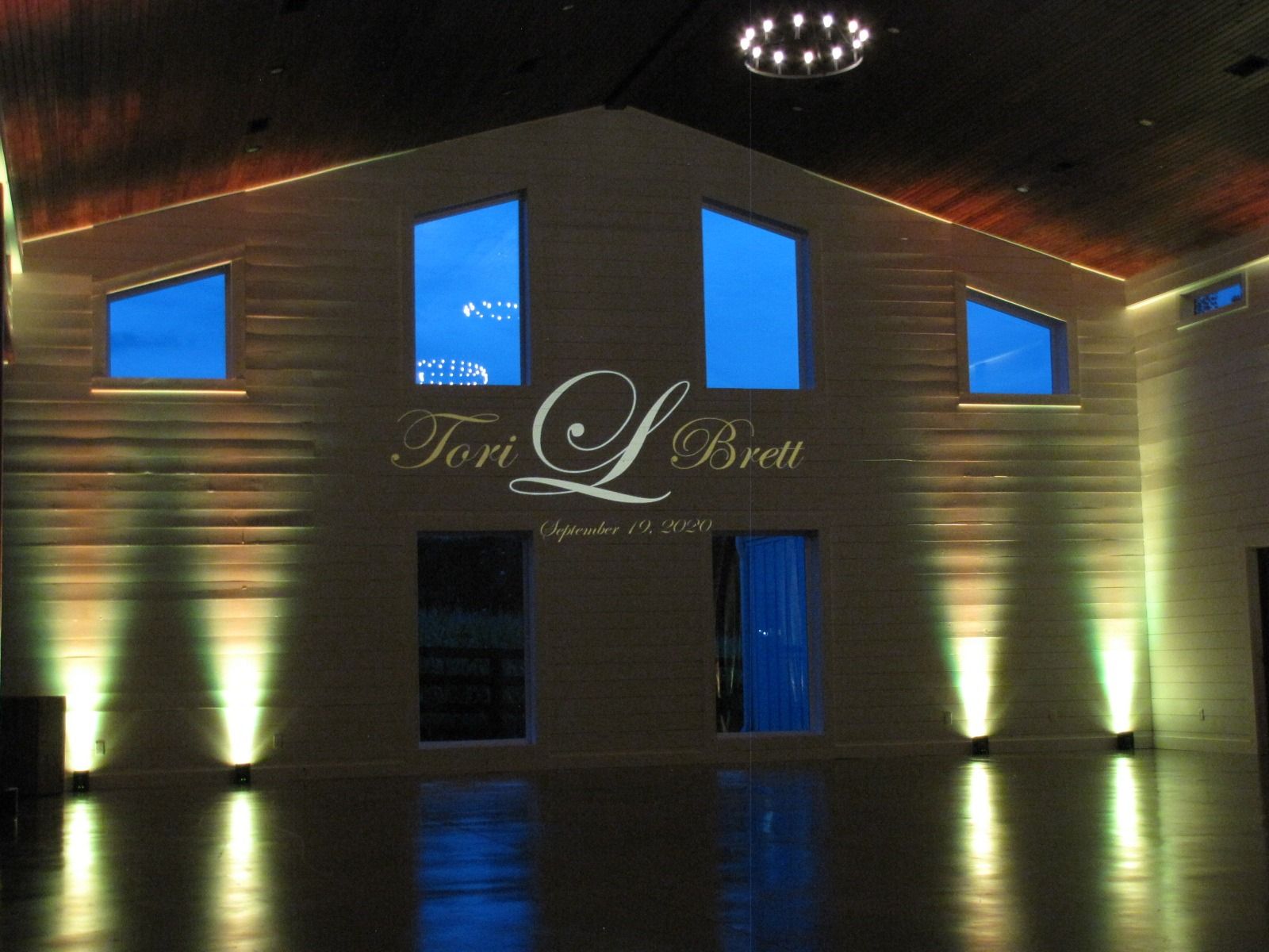 Dimly lit building interior with blue windows and illuminated walls, showing a “Tori’s Bar” sign.