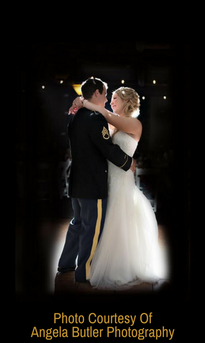 Couple slow-dancing in formal attire, silhouetted against a dark background with soft glow.