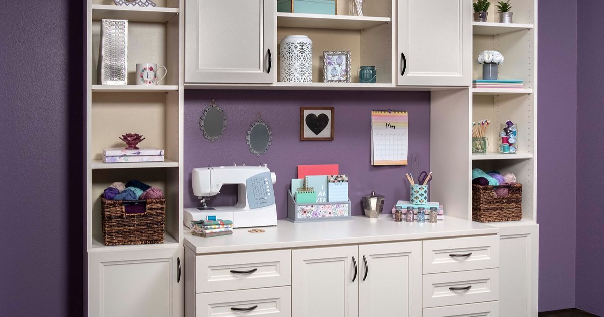Crafting workspace with cream cabinetry, purple wall, and sewing machine.