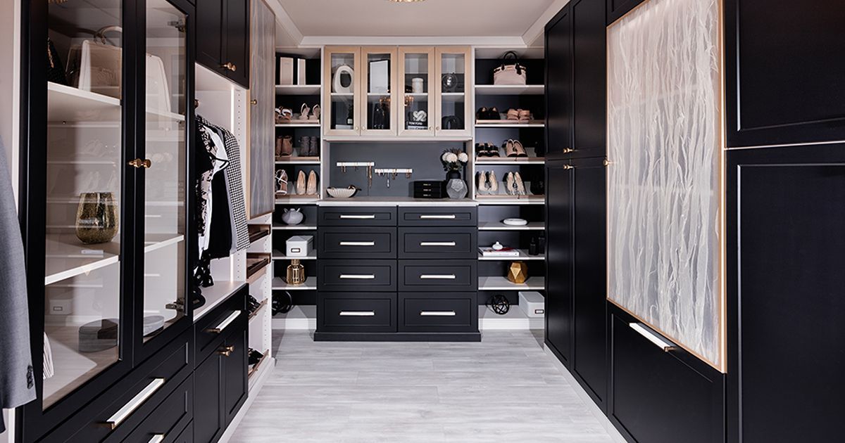 A well-organized reach in closet with hanging clothes, drawers, shelves with folded clothes, shoes, and accessories.